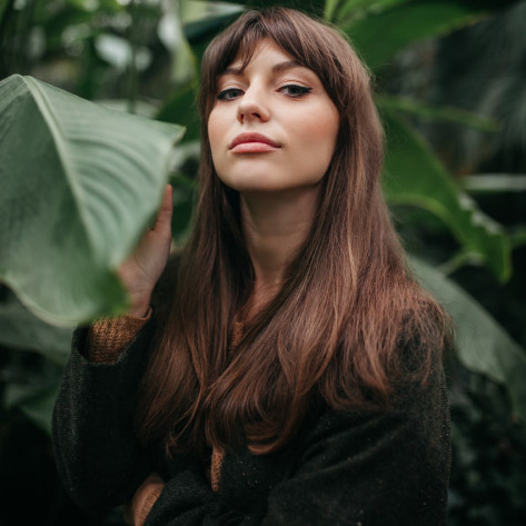 mulher com ar empoderada com planta gigante como pano de fundo